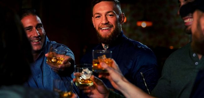 conor holding proper 12 whiskey on glass