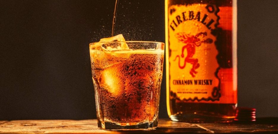fireball cinnamon whisky bottle and glass on table