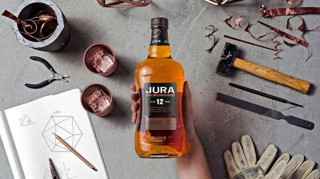 jura elixir single malt scotch whisky bottle on hand