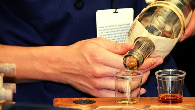 man pouring scotch on glass