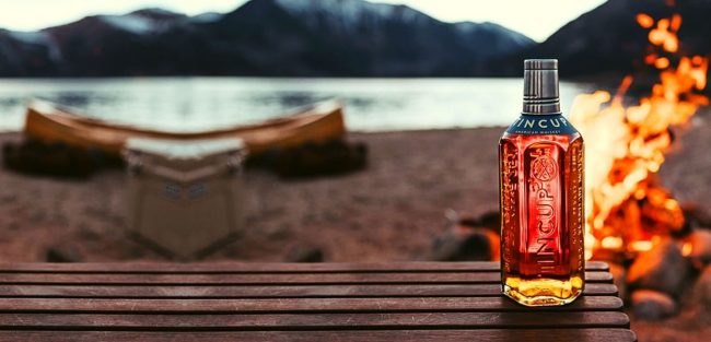 tincup american whiskey bottle beside fire